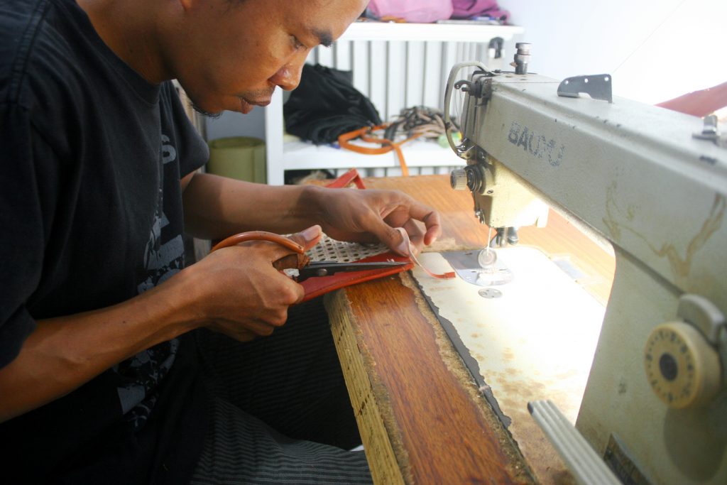 Artisan Hakim making a leather and rattan bag